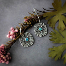 Load image into Gallery viewer, Silver earrings with blue stones on a gray surface with floral elements