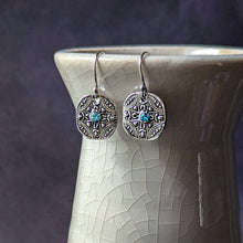 Load image into Gallery viewer, Silver earrings with blue gemstones on a textured white surface