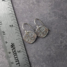 Load image into Gallery viewer, Silver earrings on a gray surface with a ruler for scale.