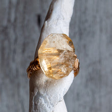 Load image into Gallery viewer, Gold ring with a large, rough-cut citrine gemstone displayed on the end of a whelk shell