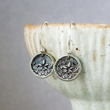 Load image into Gallery viewer, Silver earrings with floral designs on a ceramic surface