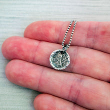 Load image into Gallery viewer, A silver flower pendant necklace with a vintage design, featuring a morning glory flower motif, held between fingers for scale