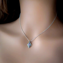 Load image into Gallery viewer, Necklace with a pendant featuring a flower and pink gemstone on a mannequin neck