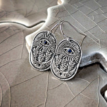 Load image into Gallery viewer, Silver earrings with eye design on a textured surface