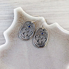 Load image into Gallery viewer, Silver earrings with blue gemstones on a textured stone surface