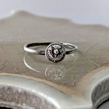 Load image into Gallery viewer, Silver ring with a circular floral design on a textured surface
