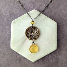 Load image into Gallery viewer, back detail of same necklace on a hexagonal stone surface.
