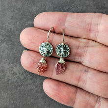 Load image into Gallery viewer, Pair of silver earrings with gemstones held between fingers on a gray background