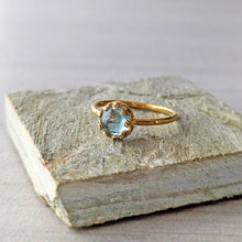 Load image into Gallery viewer, Gold ring with a blue green gemstone on a textured stone surface