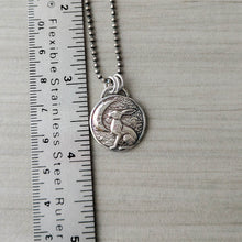 Load image into Gallery viewer, Silver rabbit pendant necklace next to a ruler on a textured surface