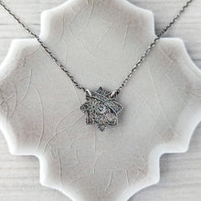 Load image into Gallery viewer, Silver necklace reverse side shown on a textured surface