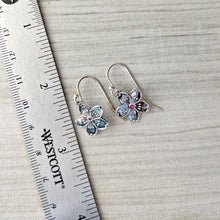 Load image into Gallery viewer, Silver flower earrings on a wooden surface with a ruler for scale.