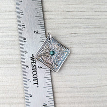 Load image into Gallery viewer, Silver pendant with a blue gemstone on a Westcott ruler for scale