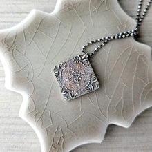 Load image into Gallery viewer, Silver pendant reversed on a textured beige surface