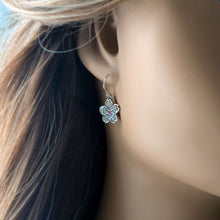 Load image into Gallery viewer, Silver flower-shaped earring worn by a person with blurred background