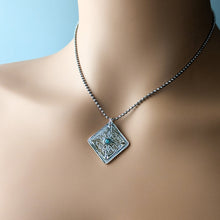 Load image into Gallery viewer, Necklace with a decorative pendant on a mannequin against a blue background