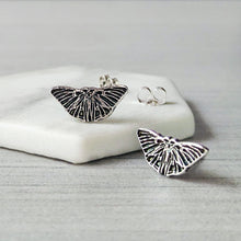 Load image into Gallery viewer, Butterfly-shaped silver earrings on a white marble surface