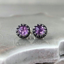 Load image into Gallery viewer, Pair of stud earrings with purple gemstones set in an intricate silver frame on a neutral ceramic tile.