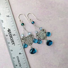 Load image into Gallery viewer, Silver earrings with blue gemstones on a neutral background with a ruler for scale.