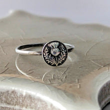 Load image into Gallery viewer, Silver ring with intricate thistle design on a reflective surface