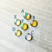 Load image into Gallery viewer, Opal stones labeled A to F at an angle to show light passing through them on a textured surface