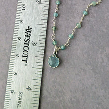 Load image into Gallery viewer, Necklace with a blue pendant and beads and a pendant next to a ruler on a gray background
