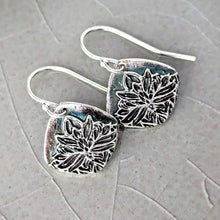Load image into Gallery viewer, Silver floral earrings on a textured gray surface