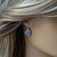 Load image into Gallery viewer, Close-up of a person wearing a silver earring.