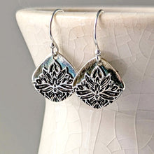 Load image into Gallery viewer, Silver floral earrings on a textured white surface