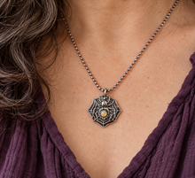 Load image into Gallery viewer, A silver spider with a smooth opal stone set into the abdomen worn by a person with dark brown curly hair wearing a dark plum v neck top
