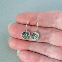 Load image into Gallery viewer, Silver earrings held between fingers against a light gray background
