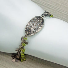 Load image into Gallery viewer, Silver bracelet with leaf design and green beads on a white mannequin arm.

