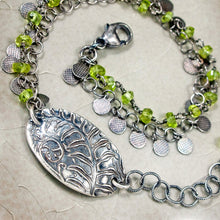 Load image into Gallery viewer, Silver bracelet with green beads and a leaf charm on a neutral surface
