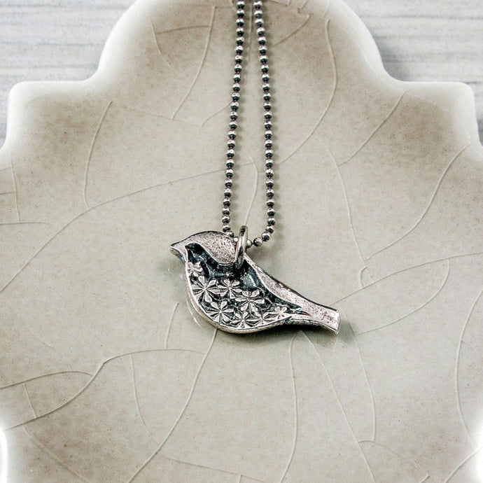 Silver bird pendant with floral detail
