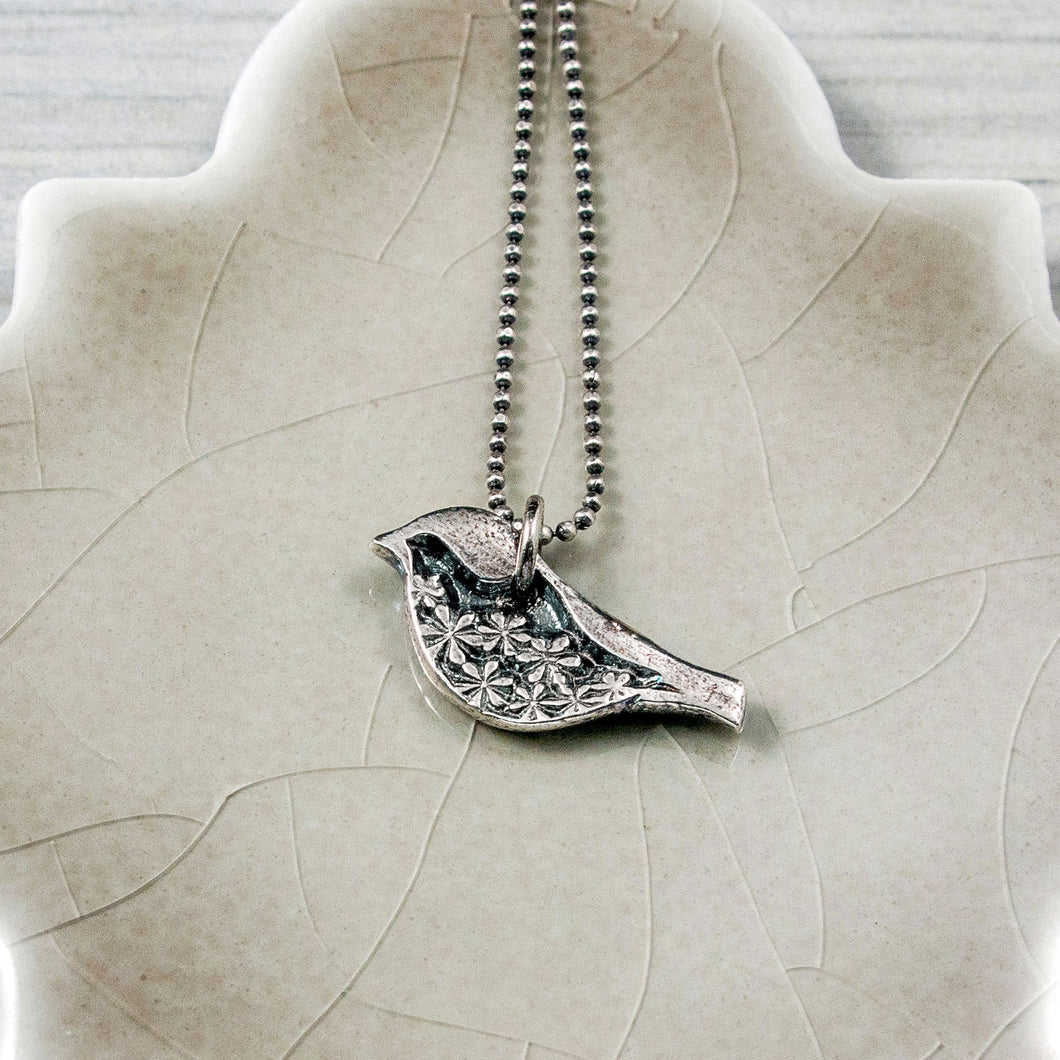 Silver bird pendant with floral detail