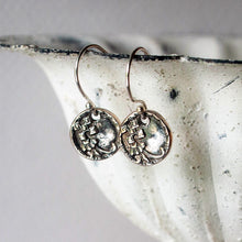 Load image into Gallery viewer, Silver earrings with intricate designs on a textured surface
