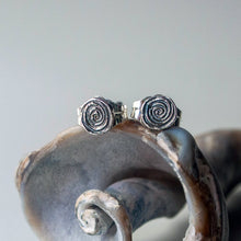 Load image into Gallery viewer, Silver spiral earrings on a fossilized whelk shell with a neutral background
