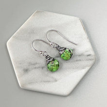 Load image into Gallery viewer, Green stone earrings with silver wire wrapping on a marble hexagonal coaster.
