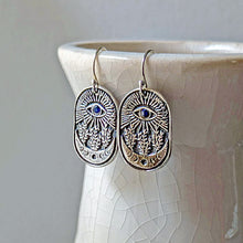 Load image into Gallery viewer, Silver earrings with blue stones on a ceramic vase
