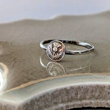 Load image into Gallery viewer, Silver ring with a circular floral design on a textured surface
