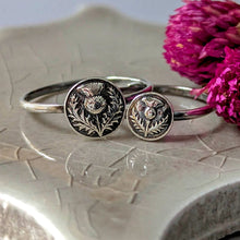 Load image into Gallery viewer, Silver rings with intricate designs on a textured surface with pink flowers.
