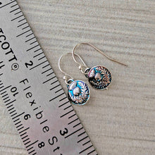 Load image into Gallery viewer, Pair of earrings with floral design next to a ruler for scale.
