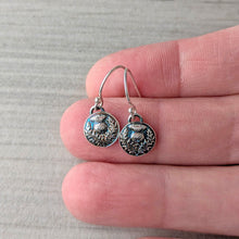Load image into Gallery viewer, Silver earrings held between fingers on a neutral background
