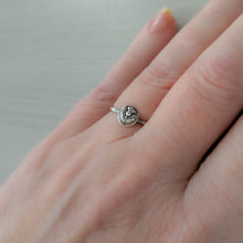 Load image into Gallery viewer, Silver ring with a circular floral design on a person's finger against a neutral background
