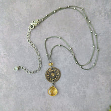 Load image into Gallery viewer, Necklace with a decorative pendant with a yellow stone drop on a gray background
