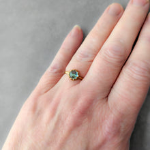 Load image into Gallery viewer, Gold ring with a blue green gemstone on a person's finger against a gray background
