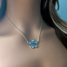 Load image into Gallery viewer, Necklace with a silver flower pendant with red gemstone on a mannequin

