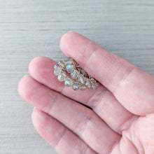 Load image into Gallery viewer, A close-up of a hand holding a pair of hoop earrings so the textural details may be seen from the angle that they would be worn
