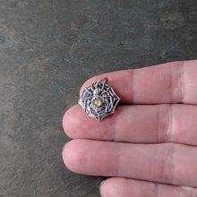 Load image into Gallery viewer, A silver spider with a smooth opal stone set into the abdomen held by a persons hand to show size
