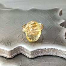 Load image into Gallery viewer, Gold ring with a large, rough-cut citrine gemstone on a textured ceramic surface
